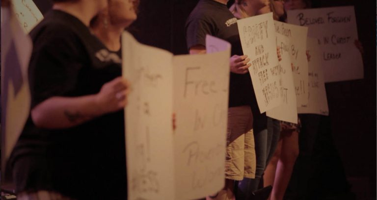 celebrate recovery members holding signs that now describe them